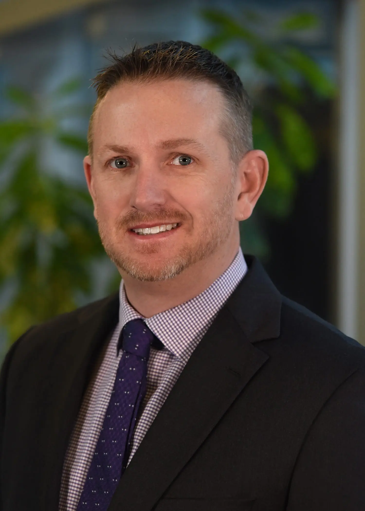 Ryan Harrington, Manager of Prime's Intermodal Division, wearing a suit jacket & red checkered tie.